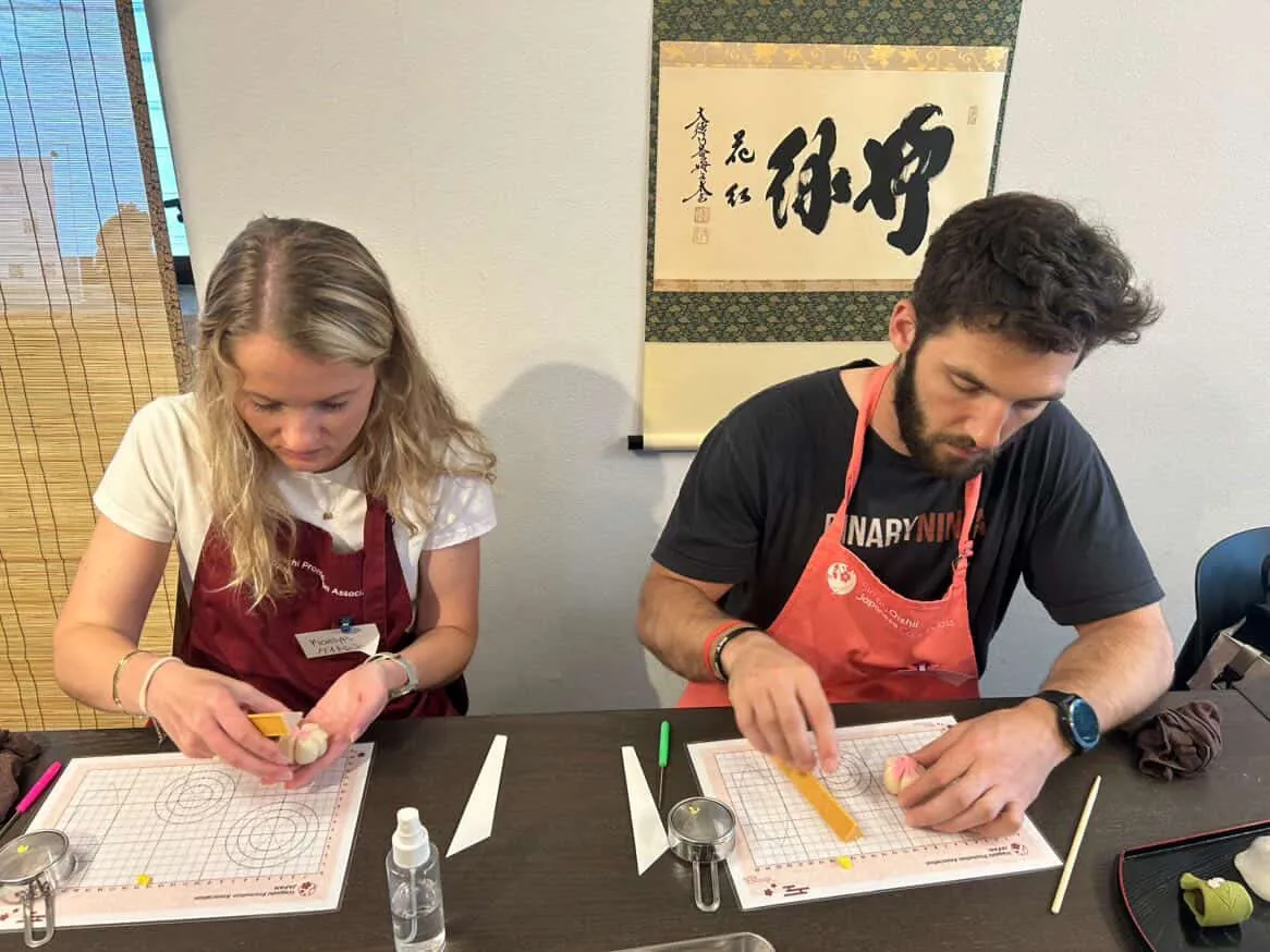 Kaitlyn and Jack in aprons, concentrating at a class table
